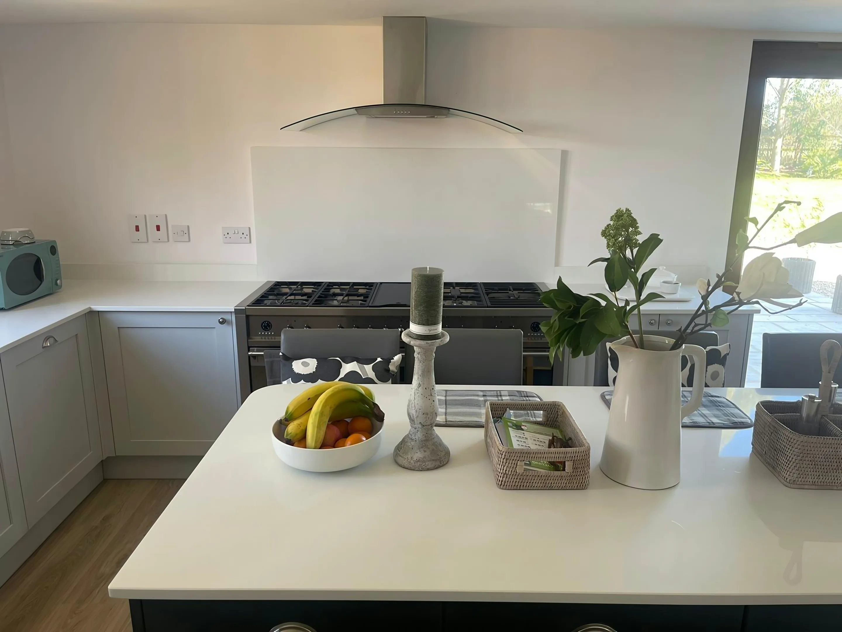 Plain white worktop on a navy island, with grey shaker units and a range cooker behind